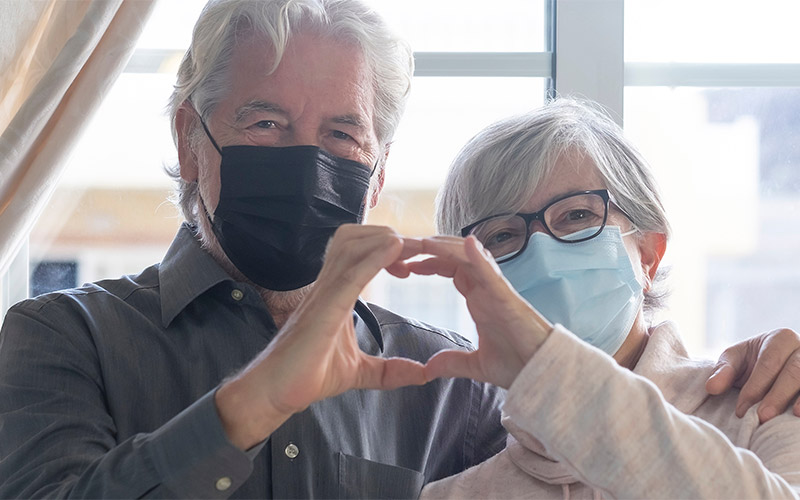 Man and woman making heart sign with hands