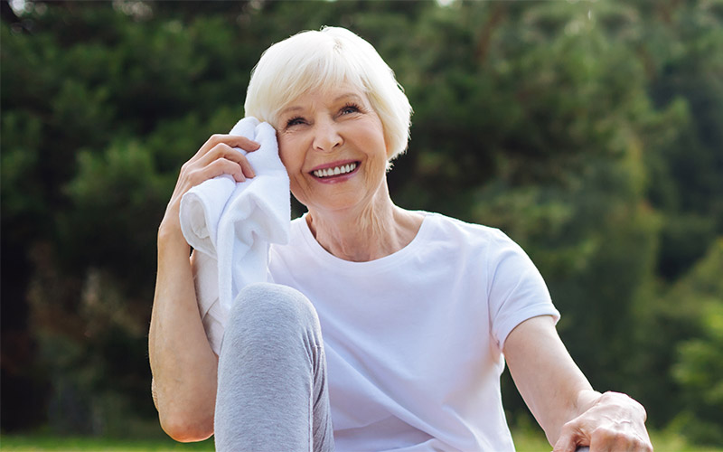 Woman wiping sweat from forehead after working out