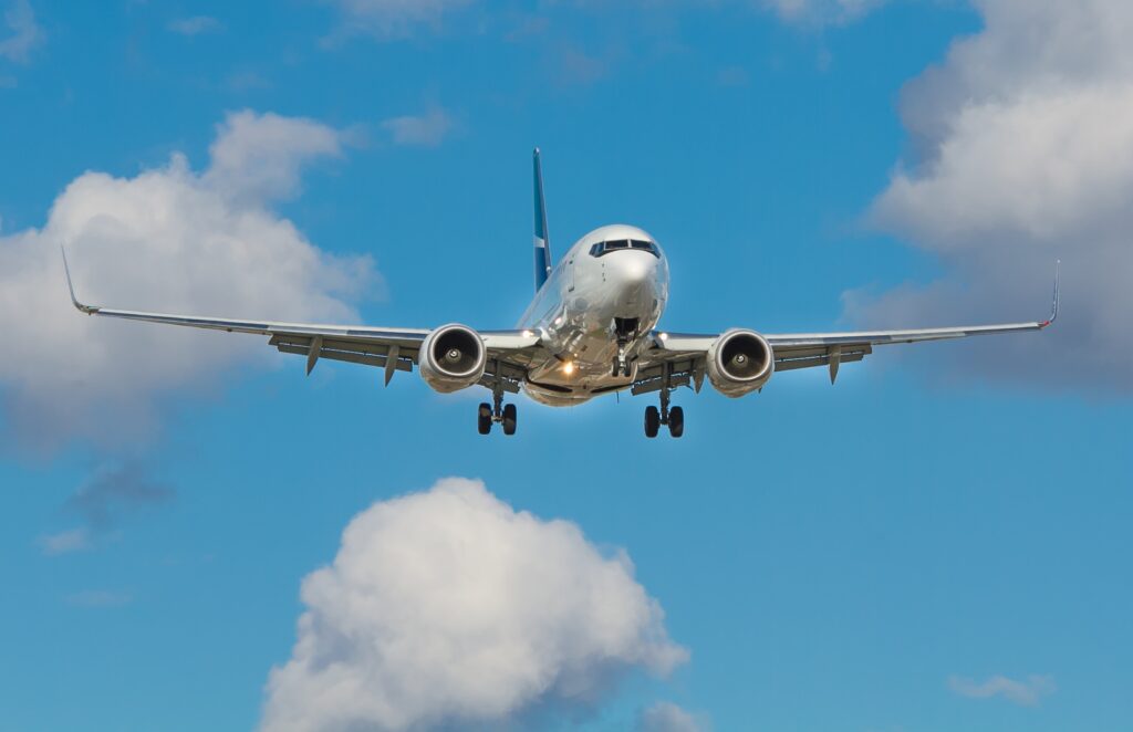 airplane in a blue sky with puffy white clouds